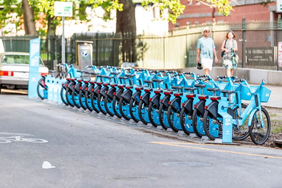 Row of blue New Orleans bike share bikes at a docked station on street